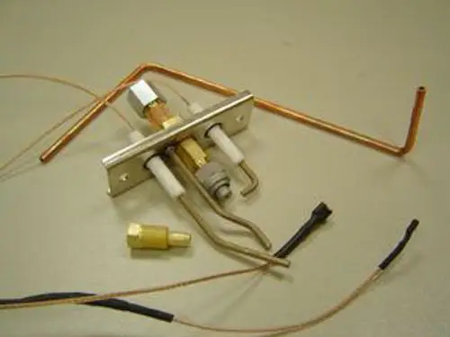 Zündbrenner von Remeha mit mehreren Rohren und elektrischen Anschlüssen auf neutralem Hintergrund. Komponenten für die Gasverbrennung und -steuerung sind deutlich sichtbar.